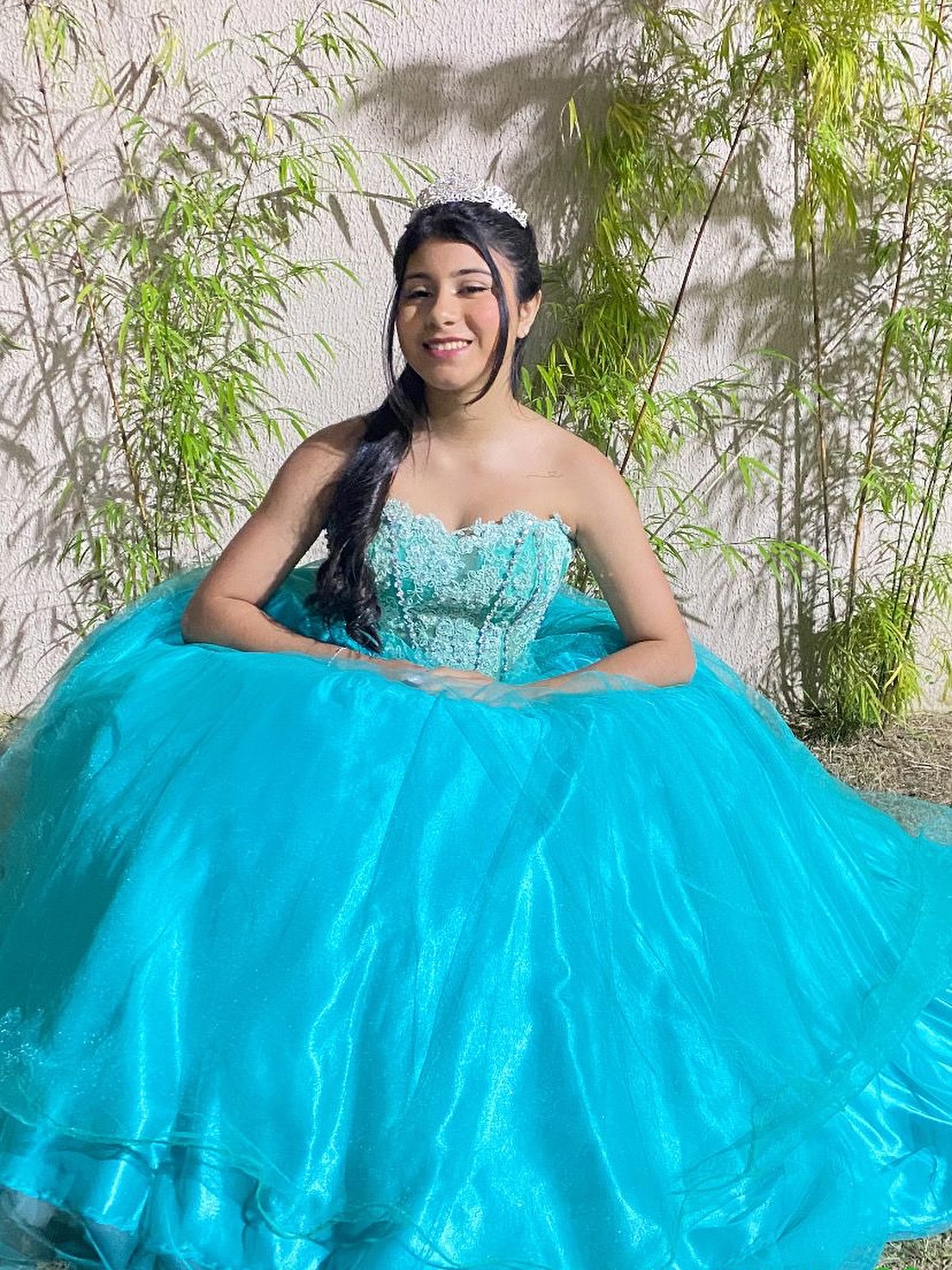 Debutante de vestido azul-turquesa posando ao ar livre