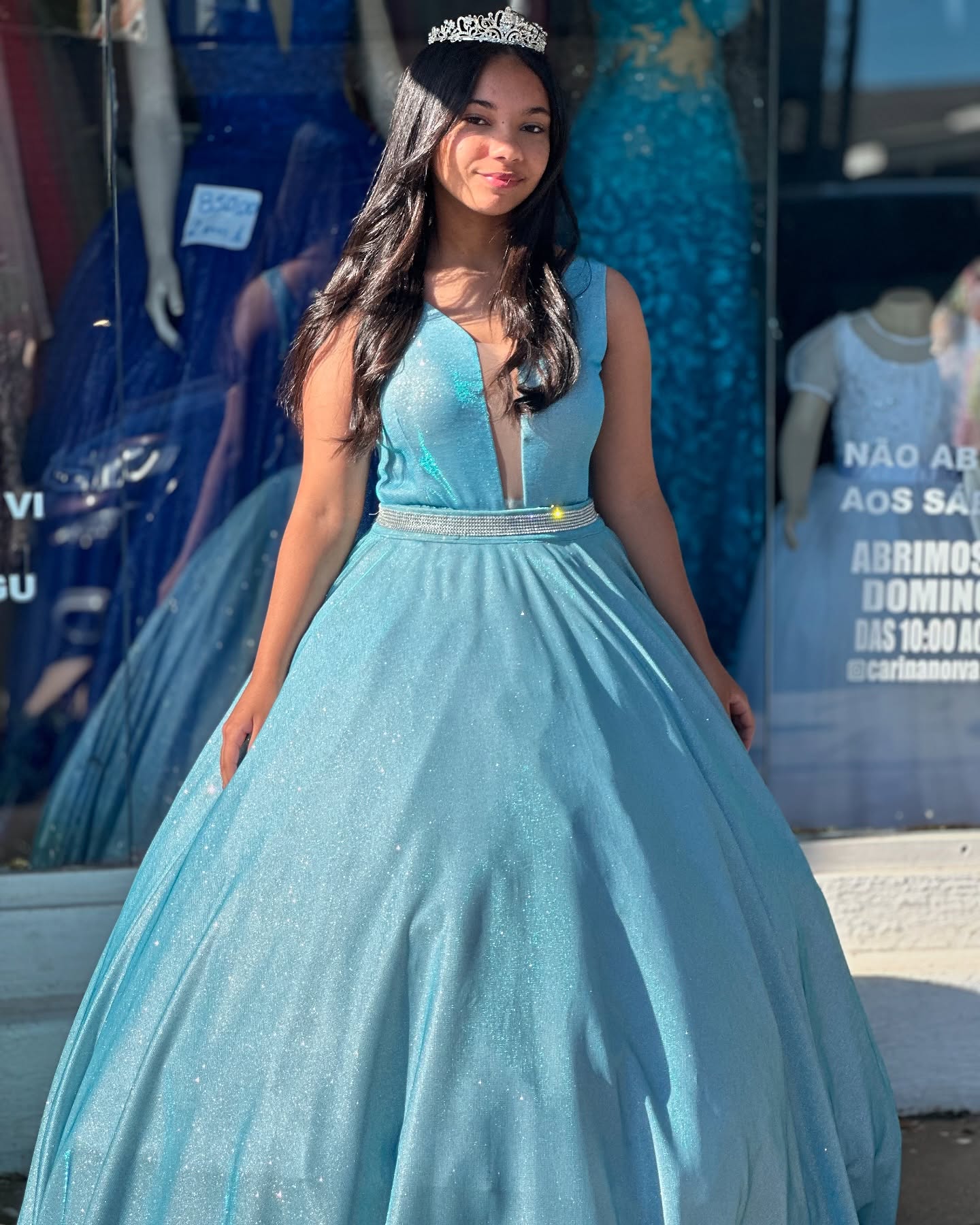 Noiva com vestido azul claro cintilante e coroa na entrada da Karina Noivas